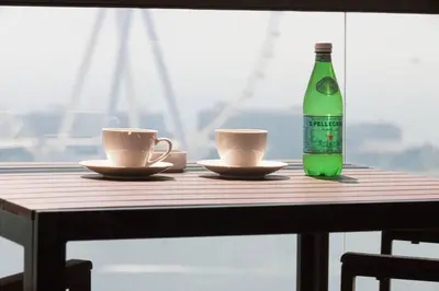 a table with two cups and a bottle of soda at Dubai Eye & Sea View, 1-min walk to JBR Beach, Luxurious Beach Retreat! in Dubai
