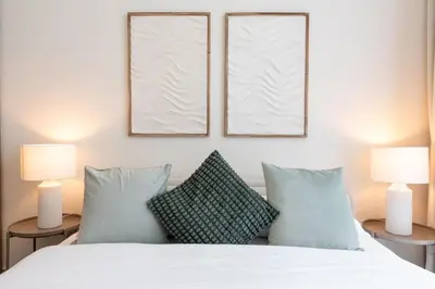 a bedroom with two lamps and a bed with two pillows at Luxury Escapes - Stylish 2BR Apt with City View in Forte Downtown in Dubai