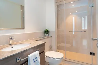 a bathroom with a shower and a toilet and a sink at Luxury Escapes - Stylish 2BR Apt with City View in Forte Downtown in Dubai