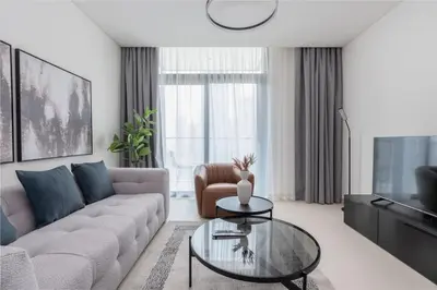 a living room with a couch and a glass table at Luxury Escapes - Stylish 2BR Apt with City View in Forte Downtown in Dubai