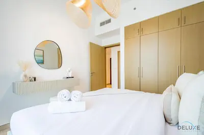 a bedroom with a white bed with two clocks on it at Alluring 1BR with Marina View at 5242 Tower 2 Dubai Marina by Deluxe Holiday Homes in Dubai