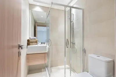 a bathroom with a shower and a toilet and a sink at Charming 2BR Home with Elegant Interior in Dubai