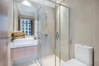 a bathroom with a shower and a toilet and a sink at Charming 2BR Home with Elegant Interior in Dubai