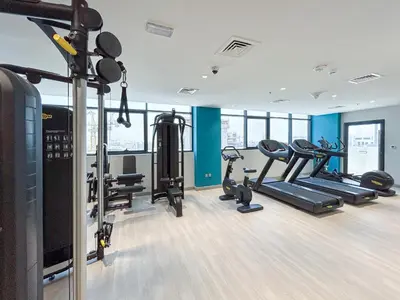a gym with treadmills and cardio equipment in a building at Charming 2BR Home with Elegant Interior in Dubai