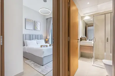 a hotel room with a bed and a bathroom at Charming 2BR Home with Elegant Interior in Dubai