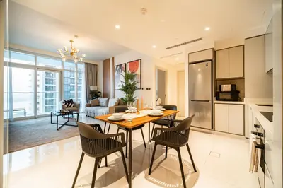 a kitchen and living room with a table and chairs at SettlerHomes - Seaside Lux Marina near Private Beach in Dubai