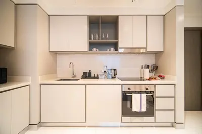 a white kitchen with white cabinets and a sink at SettlerHomes - Seaside Lux Marina near Private Beach in Dubai