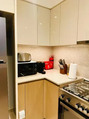 a kitchen with white cabinets and a black microwave at Incredible Burj Khalifa Views, Next to Dubai Mall in Dubai