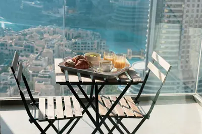 a table with a tray of food on it in front of a window at Incredible Burj Khalifa Views, Next to Dubai Mall in Dubai