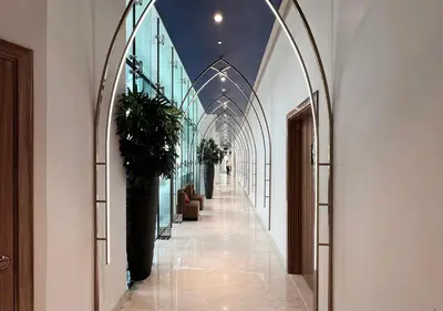 a hallway with arches and plants in a building at Lux Studio in Downtown - Damac Maison Prive - Near Burj Khalifa in Dubai