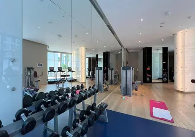 a gym with rows of exercise equipment in a building at Lux Studio in Downtown - Damac Maison Prive - Near Burj Khalifa in Dubai