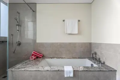 a bathroom with a bath tub and a shower at the London Condo - Forte Downtown Dubai in Dubai