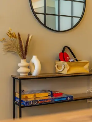 a shelf with books and a mirror on the wall at the London Condo - Forte Downtown Dubai in Dubai