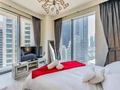 a bedroom with a large bed and a large window at the London Condo - Forte Downtown Dubai in Dubai