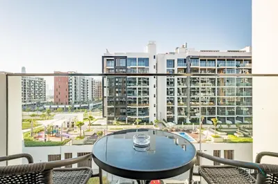 a balcony with a table and chairs and a view of a city at Inviting 1BR Apartment in Azizi Riviera 32, Al Merkadh by Deluxe Holiday Homes in Dubai