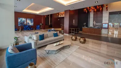 a lobby with two couches and a table in a building at Chic 1BR in The Residence at Marina Gate 2, Dubai Marina by Deluxe Holiday Homes in Dubai
