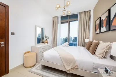 a white bedroom with a large bed and a window at Chic 1BR in The Residence at Marina Gate 2, Dubai Marina by Deluxe Holiday Homes in Dubai