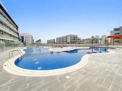 a large swimming pool in a city with buildings at Cozy Studio with sun terrace in Dubai