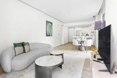 a living room with a couch and a tv at 5 min to Metro - New 1 Bed in Business Bay in Dubai