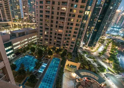an overhead view of a city at night with a pool at Your 2BR with Burj Khalifa View in Dubai