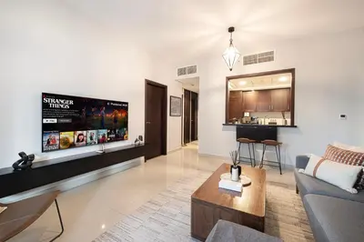 a living room with a couch and a tv at Your 2BR with Burj Khalifa View in Dubai