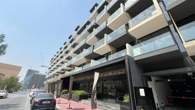 a large building on a street with cars parked outside at 1-Bed in Binghatti Crescent, Next to Circle Mall in Dubai