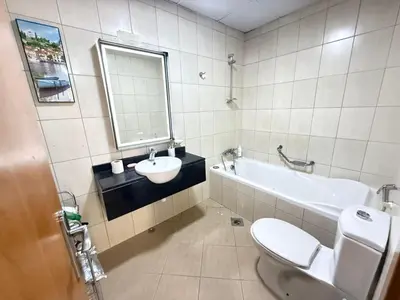 a bathroom with a sink and a tub and a toilet at Lavender Oasis - Entire Spacious 1 flat in Jumeirah Village Circle in Dubai