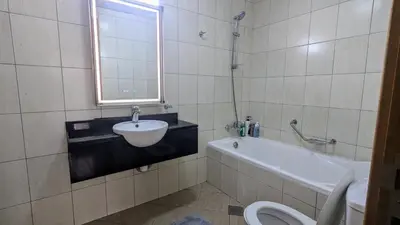 a bathroom with a sink and a tub and a toilet at Lavender Oasis - Entire Spacious 1 flat in Jumeirah Village Circle in Dubai