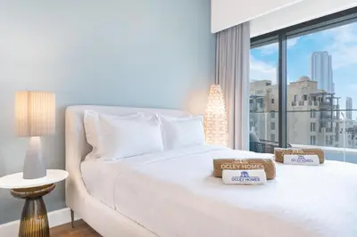 a bedroom with a white bed and a large window at Stunning Renovated Home with Full Burj Khalifa View in Dubai