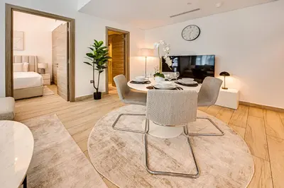 a living room with a table and chairs and a tv at Cozy 2 bedroom apartment in Dubai Marina in Dubai