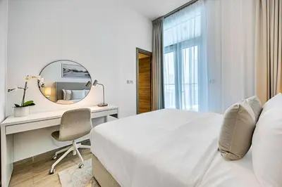 a bedroom with a bed and a desk and a mirror at Cozy 2 bedroom apartment in Dubai Marina in Dubai