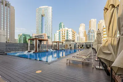 a swimming pool on top of a building with tall buildings at Cozy 2 bedroom apartment in Dubai Marina in Dubai