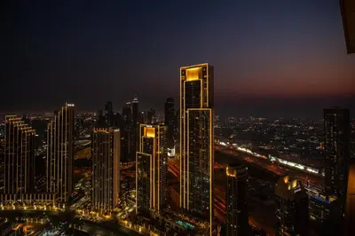 a night view of a city with tall buildings at Escape24 2BR in Address Opera with Skyline Views near Burj Khalifa in Dubai