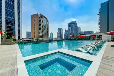 a large swimming pool with a city skyline in the background at Studio MAG 318 City View Business Bay in Dubai