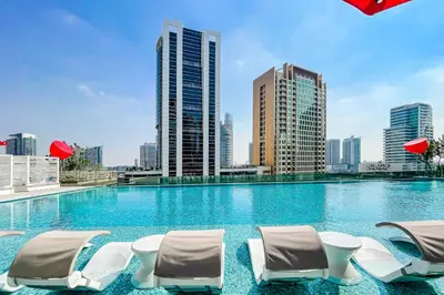 a swimming pool with chairs and a city skyline at Studio MAG 318 City View Business Bay in Dubai