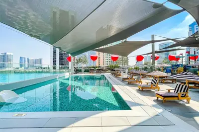 a swimming pool with chairs and tables on a building at Studio MAG 318 City View Business Bay in Dubai