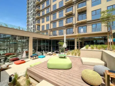 a large building with a wooden deck in front of it at GuestReady - Sky-High Comfort at Dubai Hills in Dubai