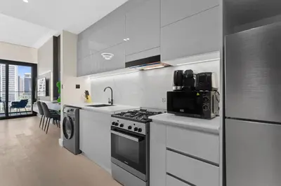 a kitchen with a stove and a refrigerator at Studio Retreat with Canal and Burj Khalifa Views in Dubai