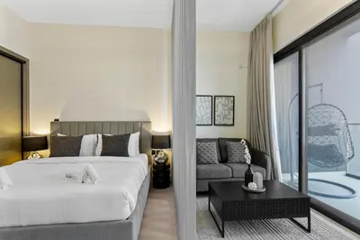 a bedroom with a large bed and a couch at Studio Retreat with Canal and Burj Khalifa Views in Dubai