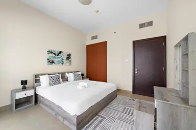 a bedroom with a large bed and a wooden door at StoneTree - Stunning Lake View - Spacious in Dubai