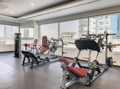 a gym with cardio equipment in a large room with windows at Stylish Studio Urban Retreat in Dubai