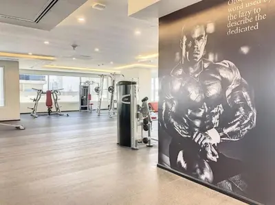 a gym with a large poster of a muscular man at Stylish Studio Urban Retreat in Dubai