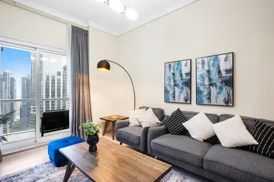 a living room with a couch and a table at StoneTree - Cozy 1 BR - Near Metro in Dubai