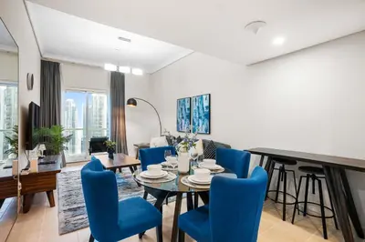 a dining room with a table and blue chairs at StoneTree - Cozy 1 BR - Near Metro in Dubai