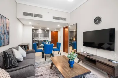 a living room with a couch and a tv at StoneTree - Cozy 1 BR - Near Metro in Dubai