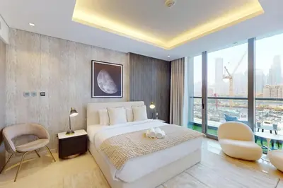 a bedroom with a large bed and a large window at The Sterling - Modern One Bedroom in Dubai