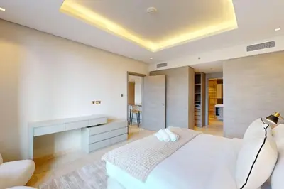 a bedroom with a white bed and a fireplace at The Sterling - Modern One Bedroom in Dubai