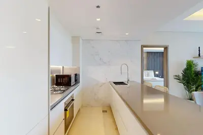a kitchen with white walls and a counter top at The Sterling - Modern One Bedroom in Dubai