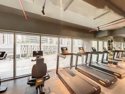 a gym with several treadmills and a large window at The Sterling - Modern One Bedroom in Dubai