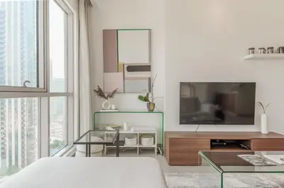 a bedroom with a large television and a table at Prime Downtown 2BR Retreat in Dubai